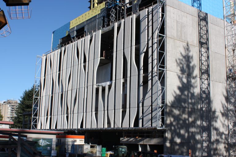 Side view of the precast concrete cladding. A flat geometric shape is cut through by vertical geometric curves that form more organic shapes.