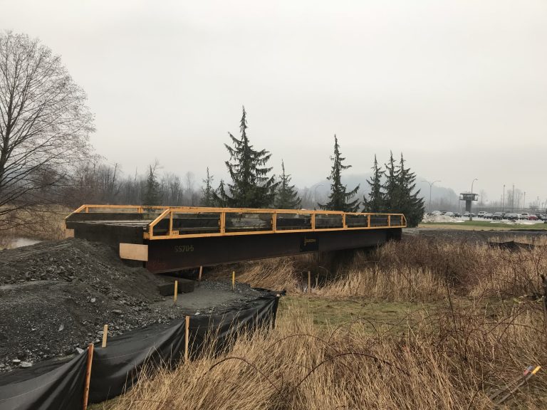 Bridge rental and sheet pile wall for Kent Institution repairs. It is a cloudy day and the grass can be seen.