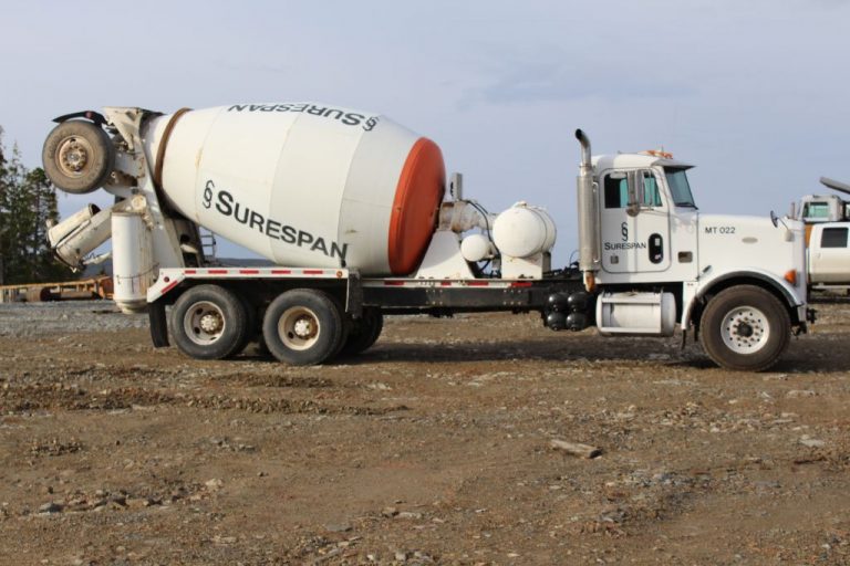 A ready-mix concrete truck can be seen on the side profile. Is it mostly white with some red marking and "Surespan' printed on the side.