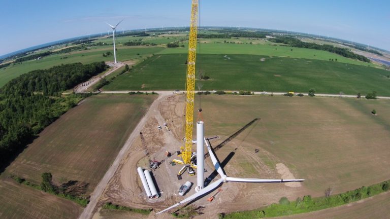A top down view of a yellow crane installing the parts of the wind turbine for the Haldimand County Wind Farm